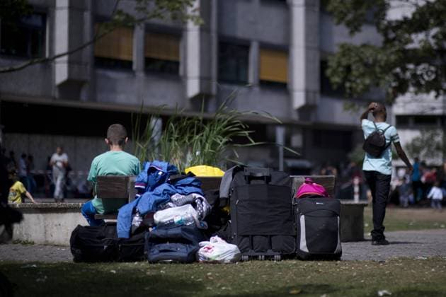 Zentrale Aufnahmeeinrichtung fuer Asylbewerber Berlin DEU, Deutschland, Germany, Berlin, 03.08.2015 Asylsuchende warten mit ihrem Gepaeck vor der Zentralen Aufnahmeeinrichtung des Landes Berlin fuer Asylbewerber, ZAA, in Berlin Tiergarten. Die Einrichtung vom Landesamt fuer Gesundheit und Soziales Lageso ist fuer Asylbewerber erst Anlaufstation und aufgrund der gestiegenen Bewerber enorm ueberfuellt. Nach Angaben des BAMF kamen von den insgesamt rund 190.000 Asylantraegen in Deutschland seit Anfang des Jahres rund 78.000 aus Staaten des Westbalkan. Nur ein Bruchteil der Antraege aber wird bewilligt - darum will die Bundesregierung ihre Asylverfahren moeglichst schnell durchziehen und die abgelehnten Bewerber zurueckschicken. Asyl seekers with their luggage waiting outside of the Zentrale Aufnahmeeinrichtung of the State Office of Health and Social Affairs Lageso in Moabit Berlin. Here im