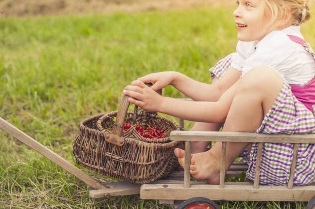 Little girl with wickerbasket sitting on a trolley model released Symbolfoto  MJF001593