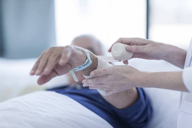 Nurse bandaging arm of senior man in a hospital, close-up model released Symbolfoto property released  ZEF006262