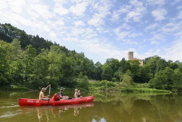 Paddler in Kanu (Kanadier) auf dem Fluss Regen an der Burg Regenpeilstein in Roding, Oberpfalz, Bayern, Deutschland model released