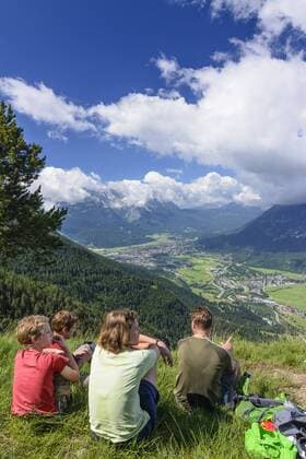 Blick auf Burgrain und Garmisch-Partenkirchen mit Wanderern in Farchant, Oberbayern, Estergebirge, Bayern, Deutschland model released