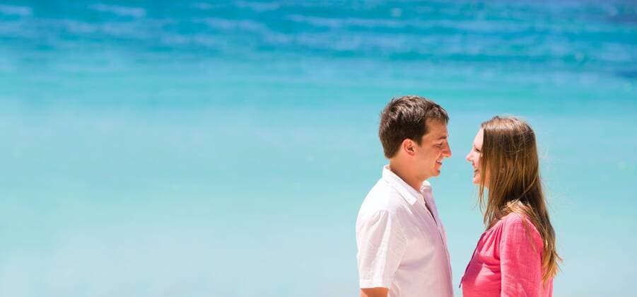 junges verliebtes Paar am Meer Young happy couple laughing looking to each other BLWS238337