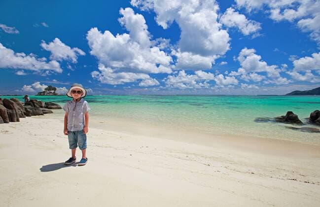 kleiner Junge steht am tropischen Sandstrand little boy standing on tropical sandy beach BLWS270934