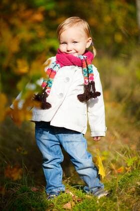 kleines Maedchen mit Schal haelt ein Herbstblatt in der Hand little girl with scarf holding autumn leaf BLWS272259