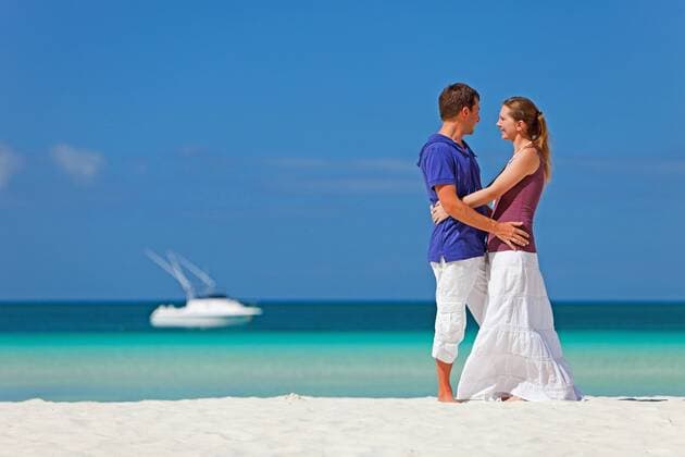 junges Paar steht am tropischen Sandstrand und umarmt sich young couple embracing on tropical beach BLWS269828