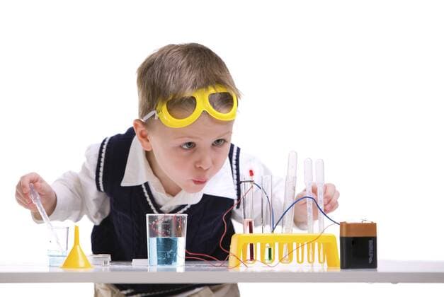 kleiner Forscher experimentiert in einem Labor Early education. Young boy performing chemistry experiments BLWS237756