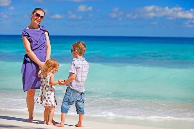 eine junge Mutter steht mit ihren zwei kleinen Kindern am tropischen Strand a young mother standing with her little children on tropical beach BLWS270803