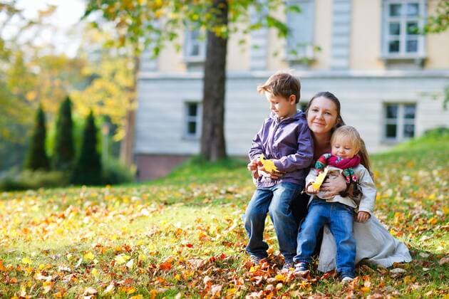junge Mutter mit ihren zwei Kindern auf einer Wiese im Herbst young mother with her two children in meadow in autumn BLWS272256