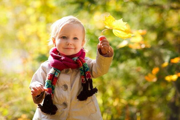 kleines Maedchen mit Schal haelt ein Herbstblatt in der Hand little girl with scarf holding autumn leaf BLWS272258