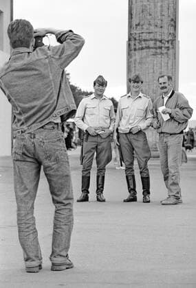 Berlin, einen Tag vor der Wiedervereinigung Feier am 03. Oktober 1990, Volkspolizisten der DDR lassen sich bei Ihrer letzten Schicht vor dem Brandenburger Tor, von Touristen fotografieren,