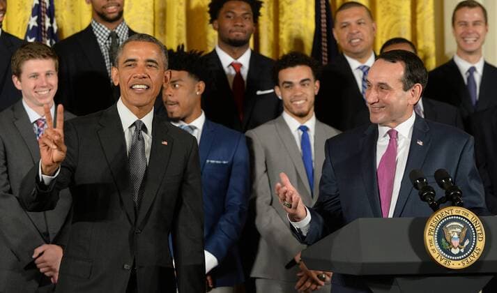 U.S. President Barack Obama holds the victory sign as he shares a laugh with Duke head basketball coach Mike Krzyzewski during a celebration event in the East Room of the White House in Washington, DC on September 8, 2015. The Duke Blue Devils won the NCAA college basketball championship in March of 2015.  WAP2015090807 PATxBENIC