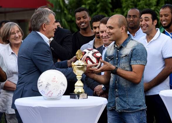 09.09.2015, xfux, Fussball Testspiel, SG Egelsbach Refugees United vs. DFB-Betriebsmannschaft, emspor v.l. DFB Praesident Wolfgang Niersbach (Deutscher Fussball Bund) uebergitb einen Ball mit Unterschriften an Kapitaen Faward Ansari (SG Egelsbach Refugees United) Fussball Testspiel, SG Egelsbach Refugees United vs. DFB-Betriebsmannschaft