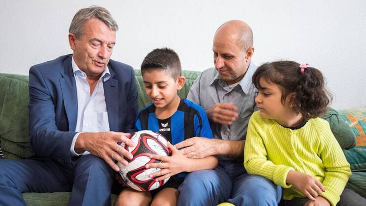 09.09.2015, xfux, Fussball Testspiel, SG Egelsbach Refugees United vs. DFB-Betriebsmannschaft, emspor v.l. DFB Praesident Wolfgang Niersbach (Deutscher Fussball Bund) zu Besuch in einem Flüchtlingscamp in Egelsbach bei einer syrischen Familie Fussball Testspiel, SG Egelsbach Refugees United vs. DFB-Betriebsmannschaft