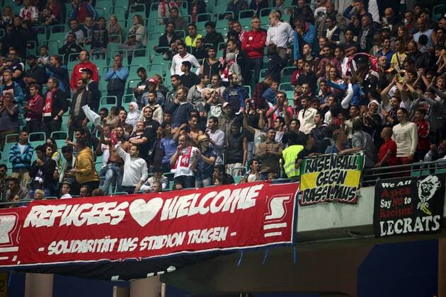 Leipzig, 11.09.2015, Red Bull Arena, Fußball, Herren, 2. Bundesliga, 6. Spieltag. , RB Leipzig vs. SC Paderborn 07 , Fans von RB Leipzig, Vor dem Fanblock der Refugees Flüchtlinge hängen Transparente mit der Aufschrift Refugees Welcome - Solidarität ins Stadion tragen, Rasenball gegen Rassismus und We all Apes Say no to Racism Lecrats . ,