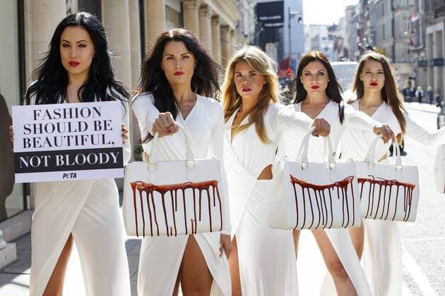 Sept. 17, 2015 - London, United Kingdom - PETA models holding handbags covered in fake blood to protest against the use of animal skins in London Fashion Week in central London. London UK  - ZUMAl94_