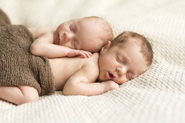 Newborn twins covered with a cloth sleeping on blanket model released Symbolfoto  SHKF000340