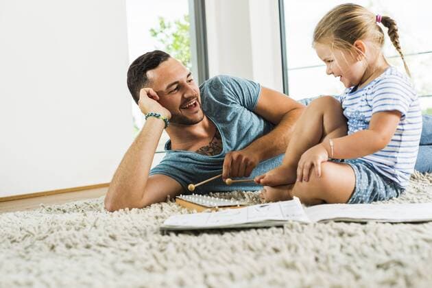 Father with daughter on rug playing glockenspiel model released Symbolfoto property released  UUF005155