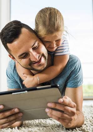 Happy father and daughter lying on rug using digital tablet model released Symbolfoto property released  UUF005158