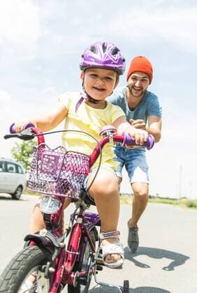 Father accompanying daughter on bike model released Symbolfoto  UUF005193