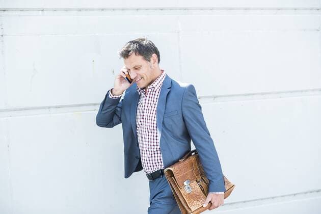 Businessman walking in the street and talking on the phone model released Symbolfoto  UUF005247