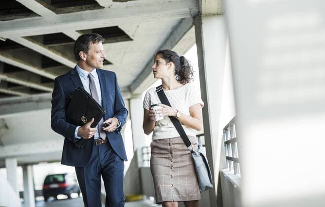 Mature businessman and young colleague walking in parking garage, talking model released Symbolfoto  UUF005298