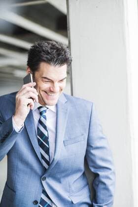 Portrait of smiling businessman telephoning with smartphone model released Symbolfoto  UUF005346