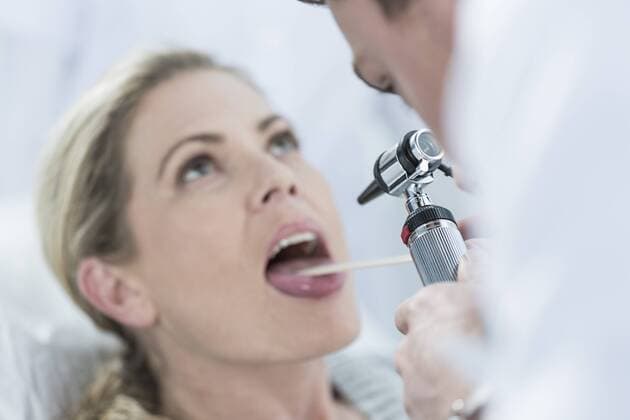 Doctor examining patient s throat model released Symbolfoto property released  ZEF005995