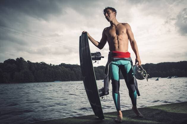 Young wakeboarder standing with his equipment at lakeshore model released Symbolfoto property released  MADF000503