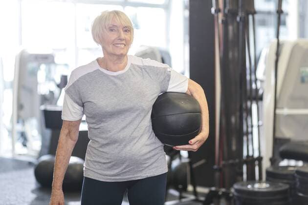 Senior woman in gym holding medicine ball model released Symbolfoto property released  MADF000513
