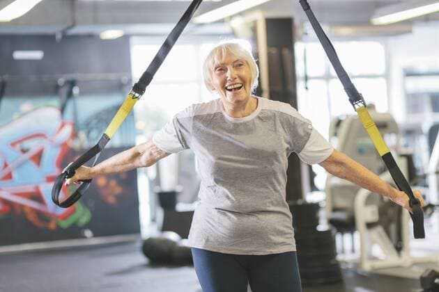 Happy senior woman in gym doing suspension training model released Symbolfoto property released  MADF000518