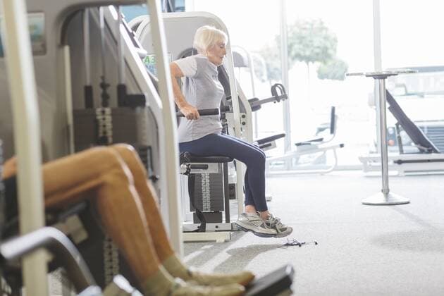 Senior woman in gym exercising at dip machine model released Symbolfoto property released  MADF000523