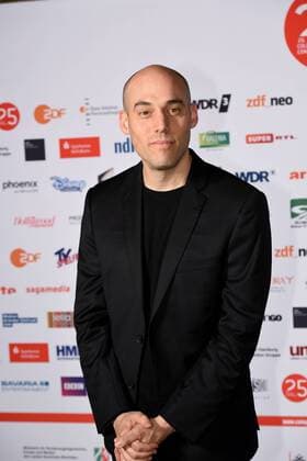 Der US-amerikanische Filmemacher Joshua Oppenheimer kommt am 01.10.2015 in Köln zur Preisverleihung der 25. Cologne Conference. Ausgezzeichnet werden herausragende Leistungen aus der internationalen Film- und Fernsehbranche. Vom 25.09. bis 01.10. findet das Festival für herausragendes Fernsehen und unabhängige Filmkultur in Köln statt.