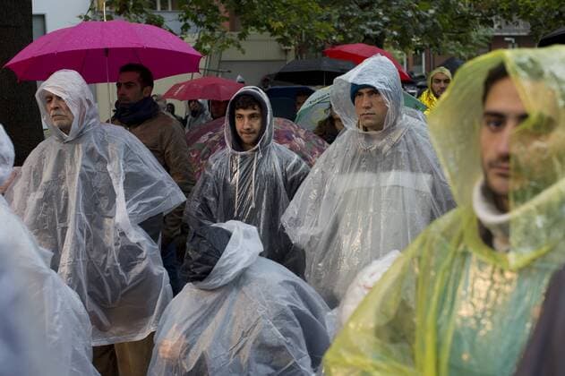 Deutschland, Berlin, Zentrale Registrierungsstelle Berlin LAGeSo in Moabit, Flüchtlinge warten auf ihre Registrierung im Regen, 08.10.2015