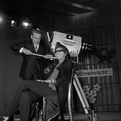 IMAGO ICONS: Josephine Baker Vergißmeinnicht, Fernsehshow, Deutschland 1964, Moderator Peter Frankenfeld mit Gaststar Josephine Baker und Kamera Copyright: Roba SiegfriedxPilz UnitedArchives13836