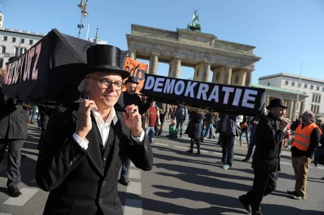 Demonstranten tragen w??hrend der Demonstration TTIP und CETA stoppen am 10.10.2015 in Berlin, Deutschland Sargatrappen vor dem Brandenburger Tor. Circa 250000 Menschen demonstrierten gegen die geplanten Freihandelsabkommen mit den USA und Canada.