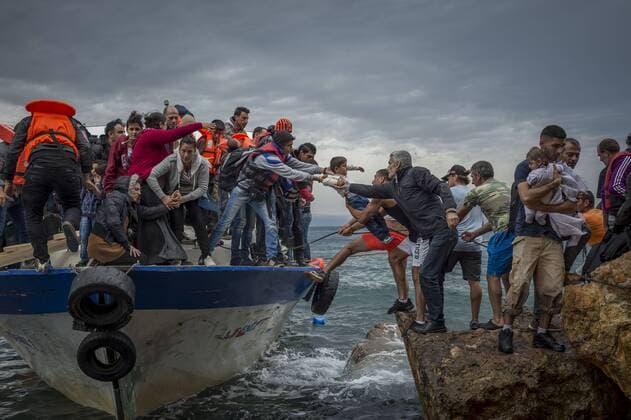 Oct. 11, 2015 - Lesbos Island, Greece - Refugees and Migrants aboard fishing boat drived by smugglers reach the Greek Island coast of Lesbos after crossing the Aegean sea from Turkey on October 11, 2015 Lesbos Island Greece  - ZUMAn230