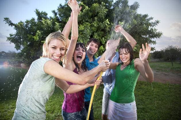 Five friends splashing with water in the garden model released Symbolfoto property released  TOYF001152