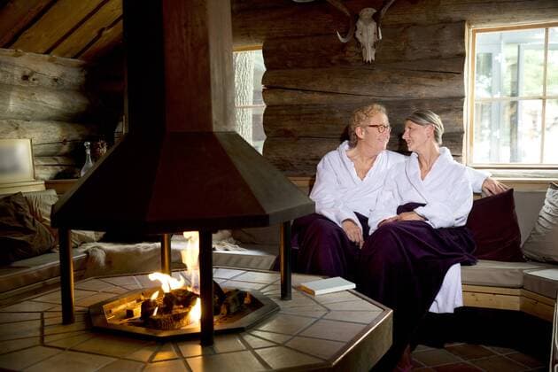 Smiling senior couple wearing bathrobes sitting at the fireplace model released Symbolfoto property released  TOYF001284