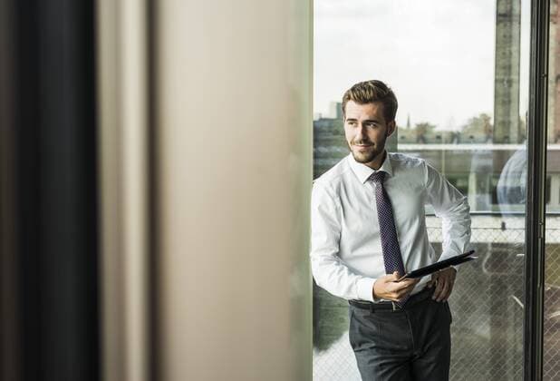 Smiling young businessman holding digital tablet model released Symbolfoto property released  UUF005523