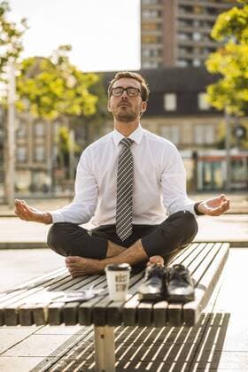 Young businessman meditating on bench model released Symbolfoto  UUF005600