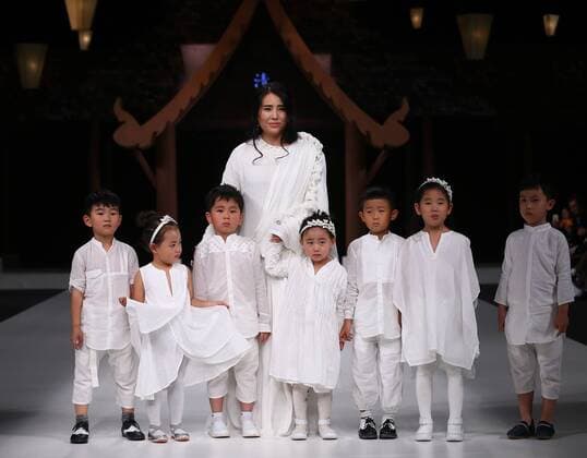 Designer Chen Qinger and children models walk the ramp at show of the creation of Qing s Zheng Qinger collection during the China Fashion Week S S 2016 in Beijing, China, Oct. 26, 2015. ) (zhs) CHINA-BEIJING-FASHION WEEK-ZHENG QINGER (CN) ChenxJianli 