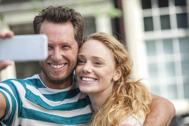 Smiling couple taking a selfie outdoors model released Symbolfoto  FMKF002095