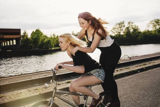 Two friends riding BMX bicycle together model released Symbolfoto  GCF000114