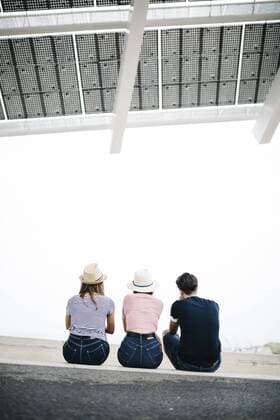Back view of three friends sitting side by side on a step model released Symbolfoto  JRFF000073