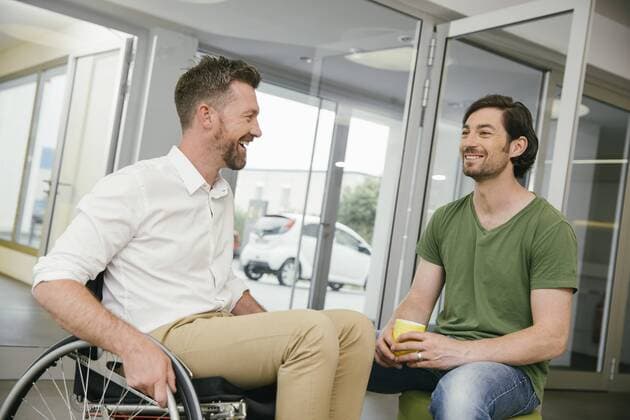 Man in wheelchair talking to colleague model released Symbolfoto property released  MFF002228