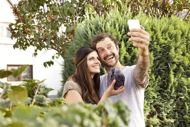Couple taking a selfie in the garden with red cabbage model released Symbolfoto property released  MFRF000445