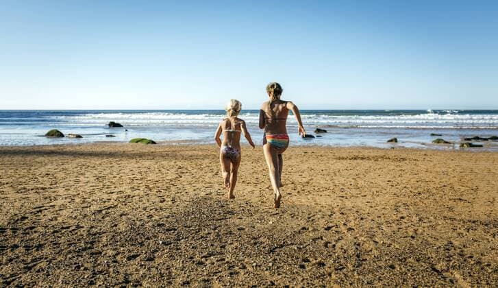Back view of two sisters running on the beach model released Symbolfoto  MGOF000608