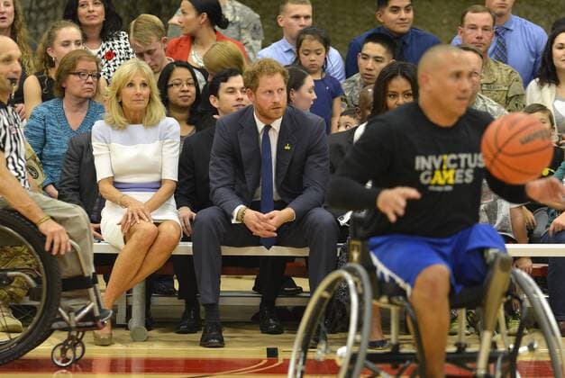 HRH Prince Harry (C) and Dr. Jill Biden sit on the sidelines as they watch a basketball game by wounded service members, October 28, 2015, at Ft. Belvoir, Virginia. The event is a celebration of the Joining Forces Initiative and the upcoming 2016 Invictus Games in Orlando, Florida, in which wounded military personnel compete in sporting competition.  WAP20151028502 MIKExTHEILER