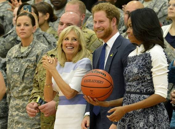 HRH Prince Harry (C), First Lady Michelle Obama (R) and Dr. Jill Biden (L) stand at the conclusion of a basketball game by wounded service members, October 28, 2015, at Ft. Belvoir, Virginia. The event is a celebration of the Joining Forces Initiative and the upcoming 2016 Invictus Games in Orlando, Florida, in which wounded military personnel compete in sporting competition.  WAP20151028513 MIKExTHEILER