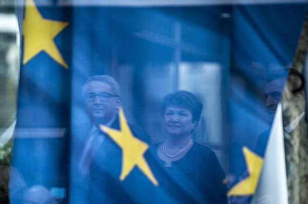 Nov. 9, 2015 - Brussels, Bxl, Belgium - The face of Jean-Claude Juncker , the president of the European Commission and Kristalina Georgieva , Vice-president of the European Commission for budget and human resources reflects over European Flag which covers the piece of Berlin Wall during The inauguration of the Kennedy Piece of the Berlin Wall in front of the Berlaymont, European Commission headquarters building in Brussels, in Brussels, Belgium on 09.11.2015 by Brussels Belgium - ZUMAw80